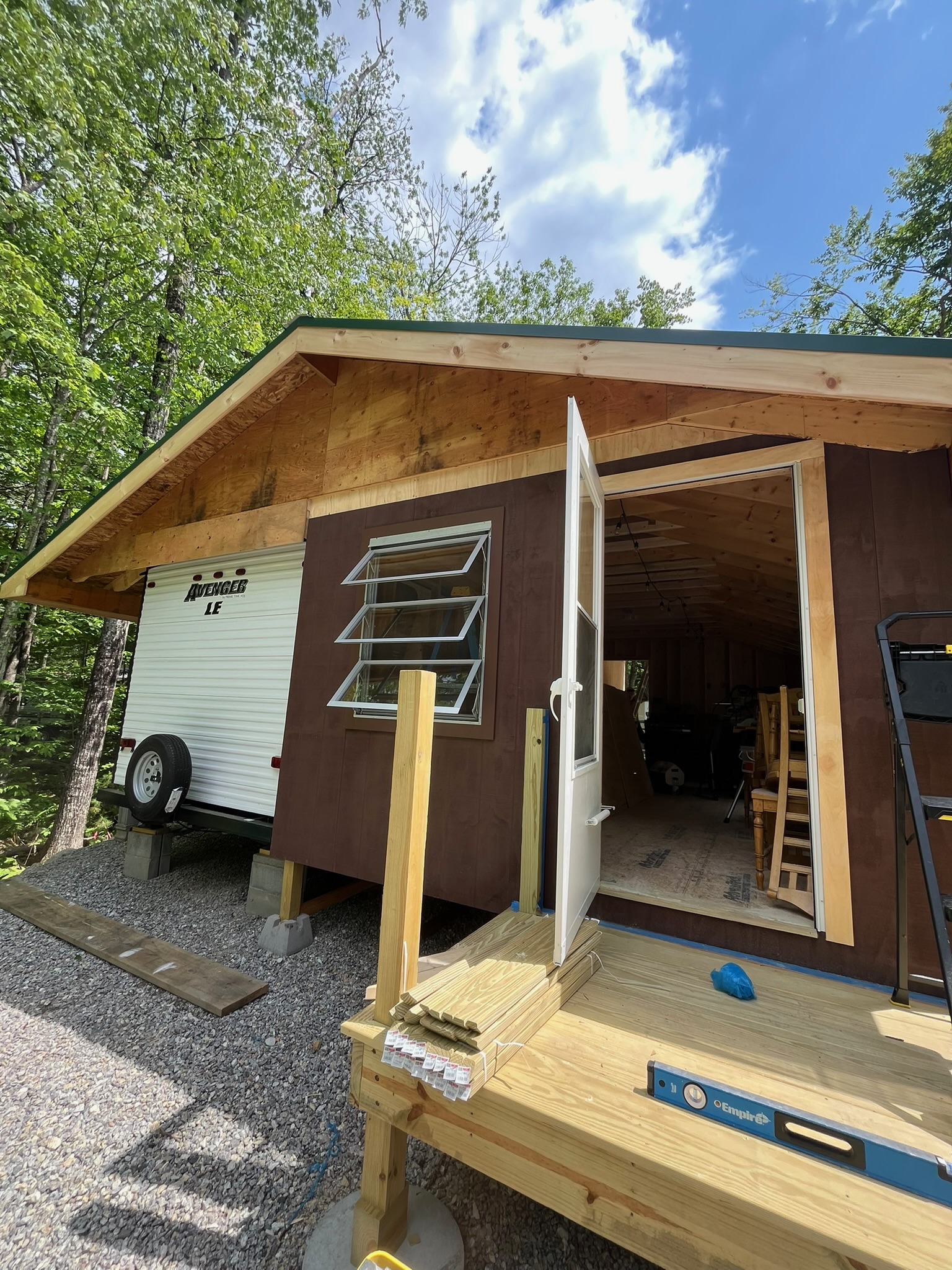 Framed camper port structure under construction, roofline extending over the camper