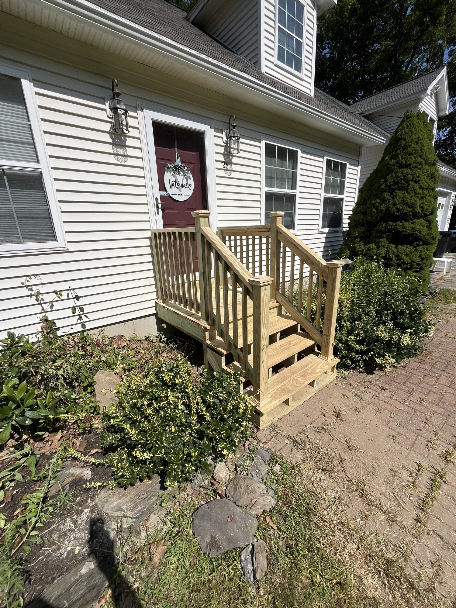 New front steps attached to the building with a brick paver landing