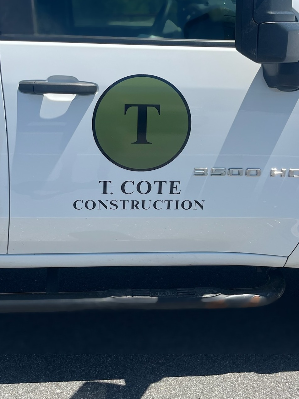 The T. Cote Construction logo on the door of the company truck